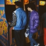A couple playing arcade games, namely Ms Pac-Man, New York City, circa 1985.